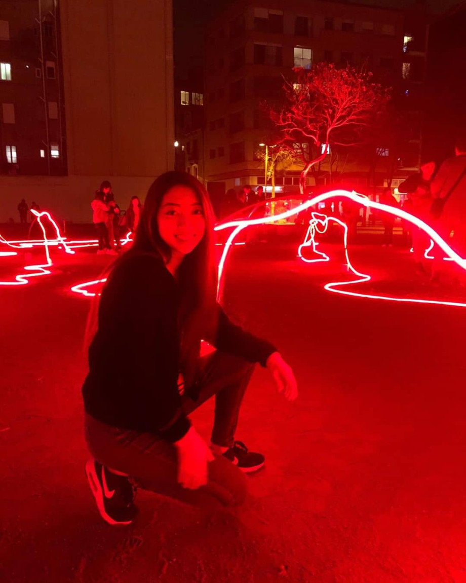 Girl in front of psychedelic red light sculpture.