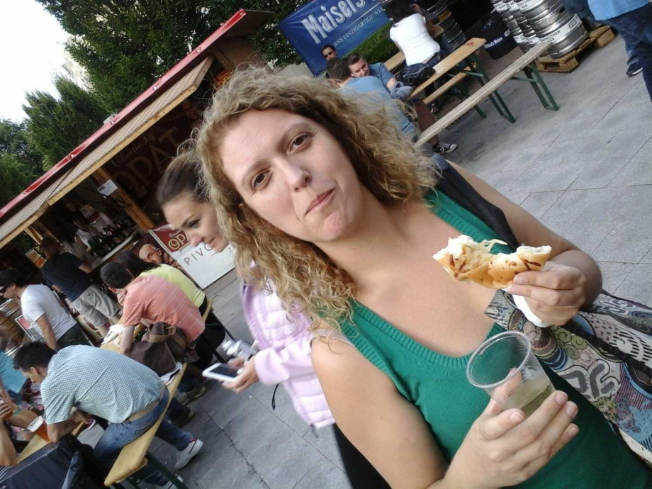 Spanish teacher Eva at a food festival eating something delicious.