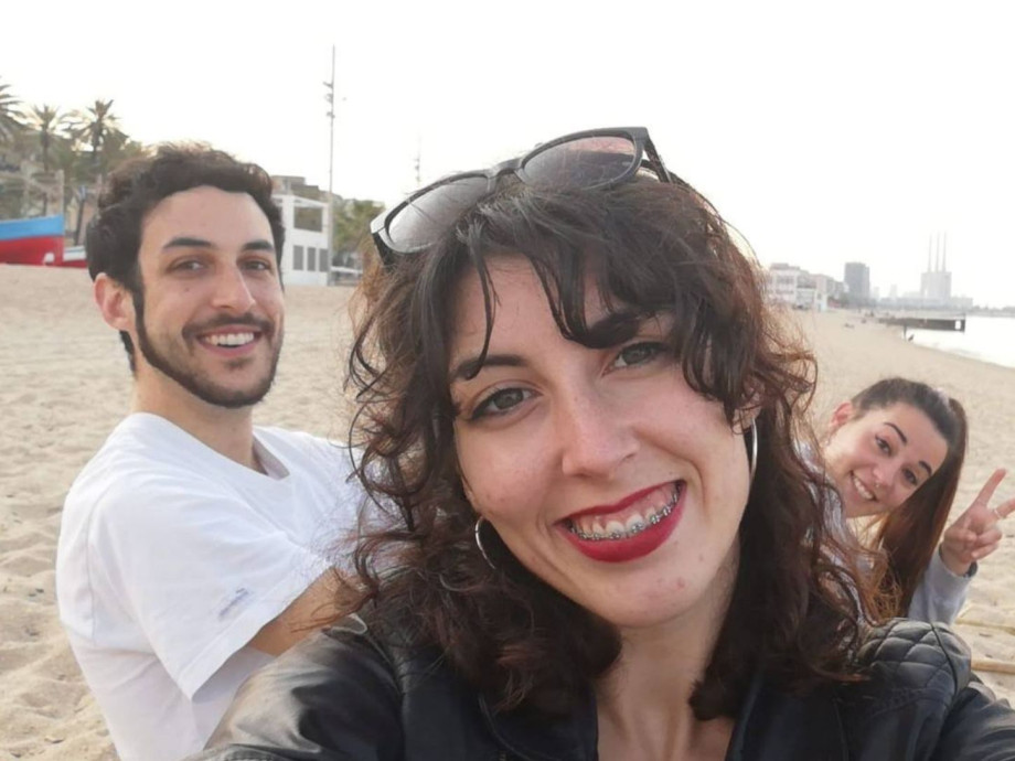 3 smiling people at the beach in Barcelona.