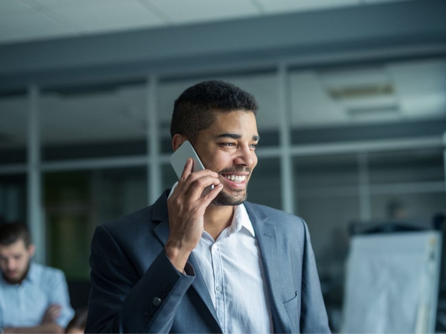 Smiling man at work making a phone call.