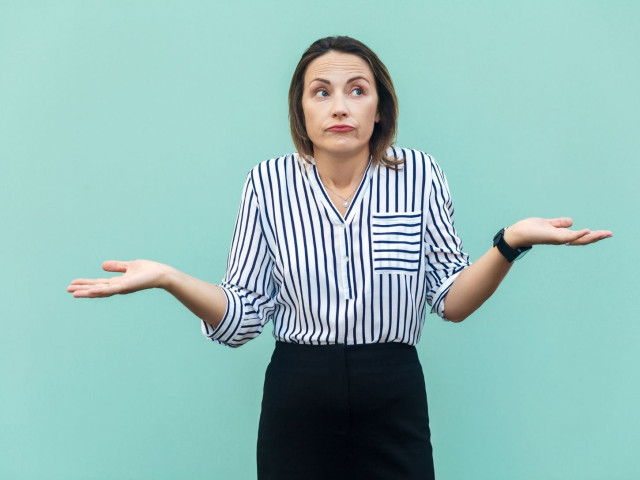 Woman looking confused with hands up at her sides