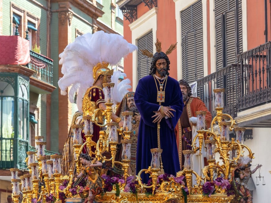 Jesus on an Easter float with Spanish buildings in background.