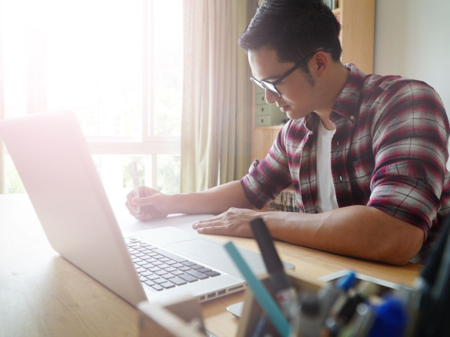 Young man studying in front of his laptop computer