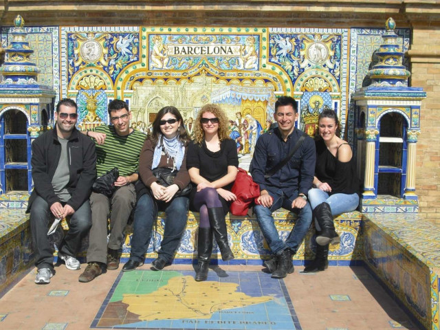 Group of friends in Plaza de España in Sevilla sitting on the Barcelona bench