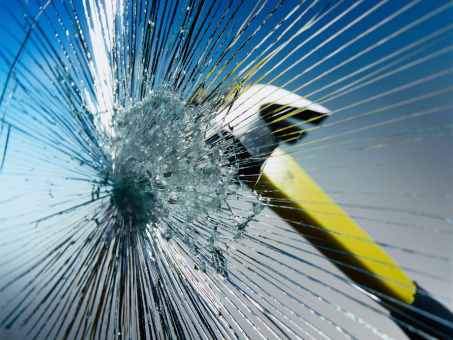 A hammer breaking glass.