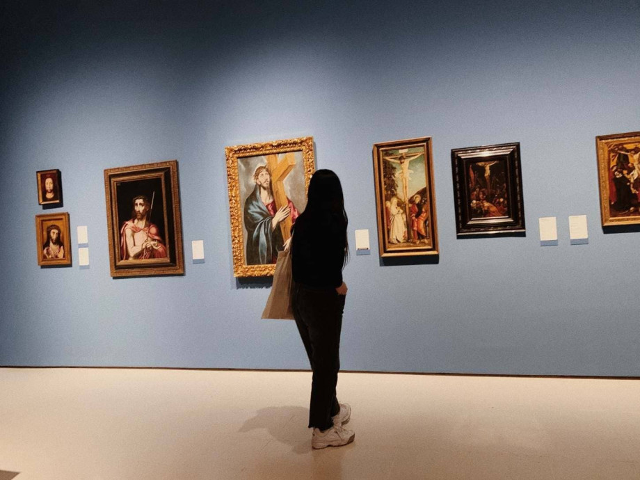 Girl looking at paintings in a museum.