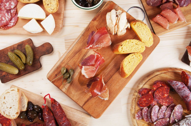 A large board of ham, sausage and cheese