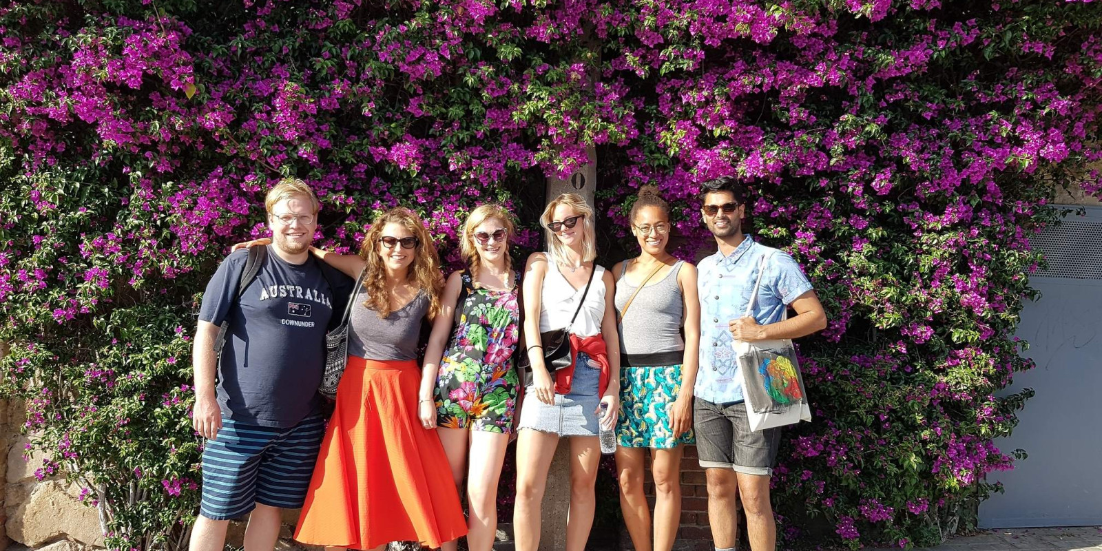 Speakeasy students standing in front of flowers